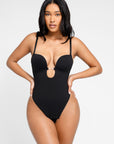 Woman wearing a black bra bodysuit on a white background