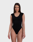 Woman wearing a black sleeveless swimsuit on a white background