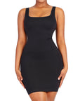 A woman wearing a black mini dress with a square neckline and sleeveless design.