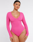 A model wearing a pink long sleeve ribbed V-neck bodysuit.