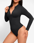 A model wearing a long sleeve black zip up thong bodysuit.