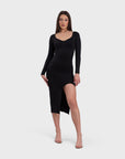 A woman in a black midi dress with a V-neckline and a side slit.