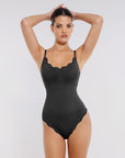 Black bodysuit with lace details on a model against a plain background