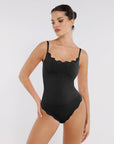 Model wearing a black bodysuit with lace details on a white background