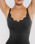 Black bodysuit with lace detailing on a plain background