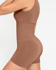 A person wearing a brown square neck short jumpsuit.