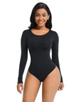 A woman wearing a black long sleeve shaping bodysuit.