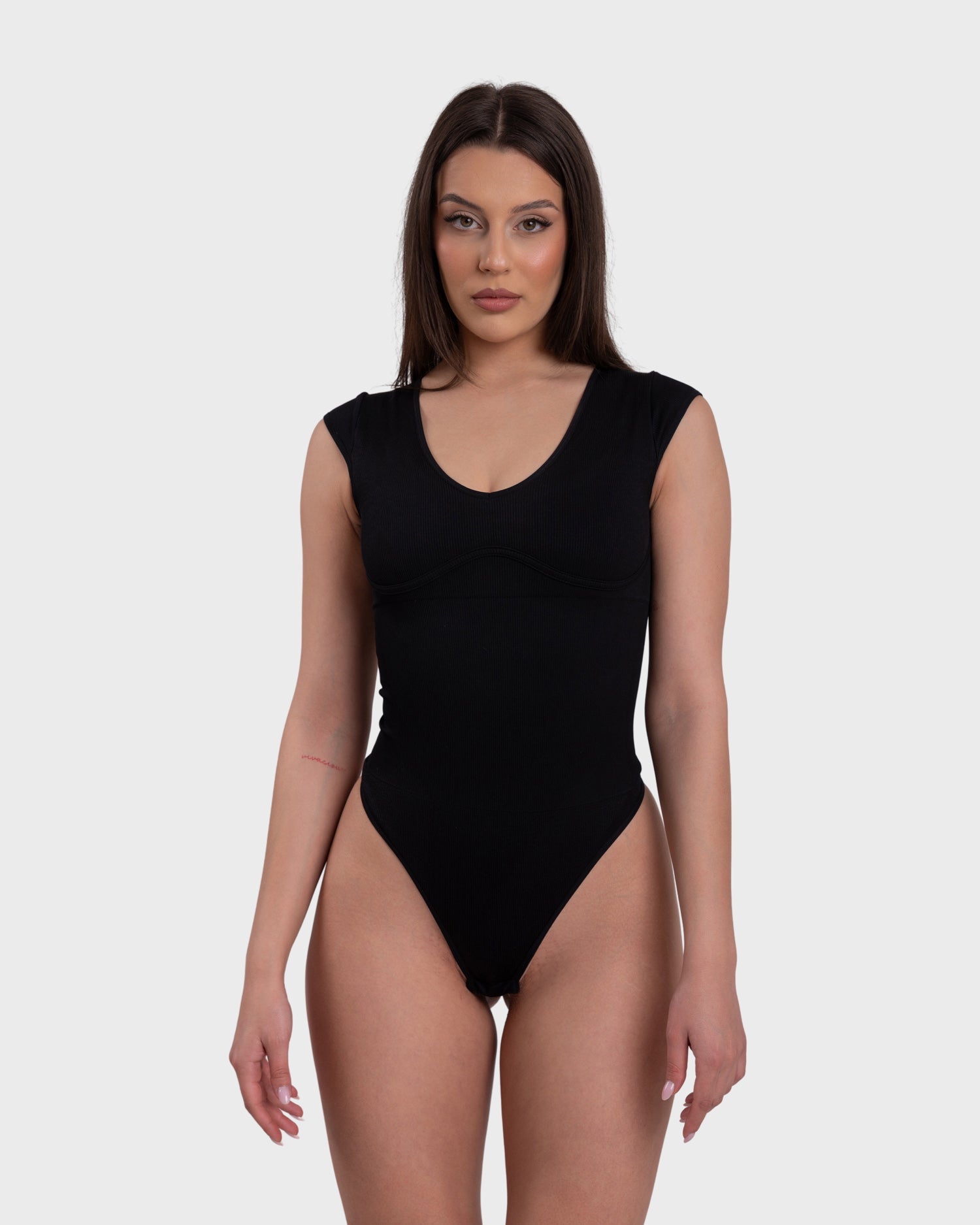 Woman wearing a black sleeveless swimsuit on a white background