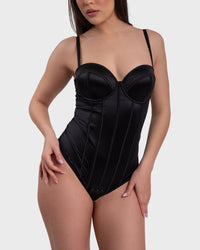 A woman wearing a black corset bodysuit with adjustable straps.