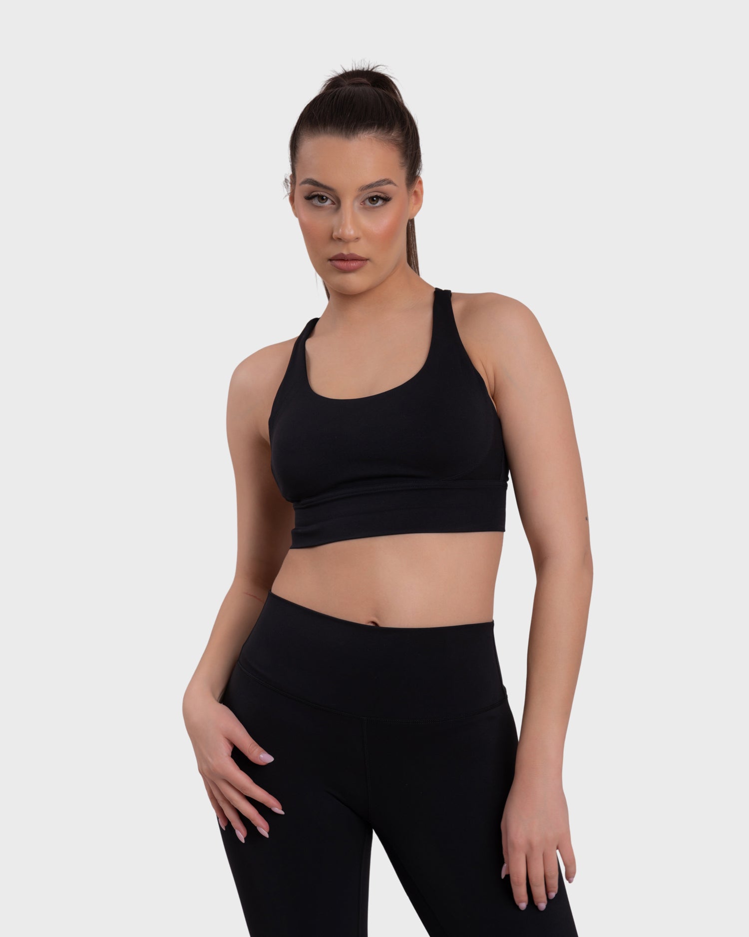 A woman wearing a black sports bra and matching leggings.