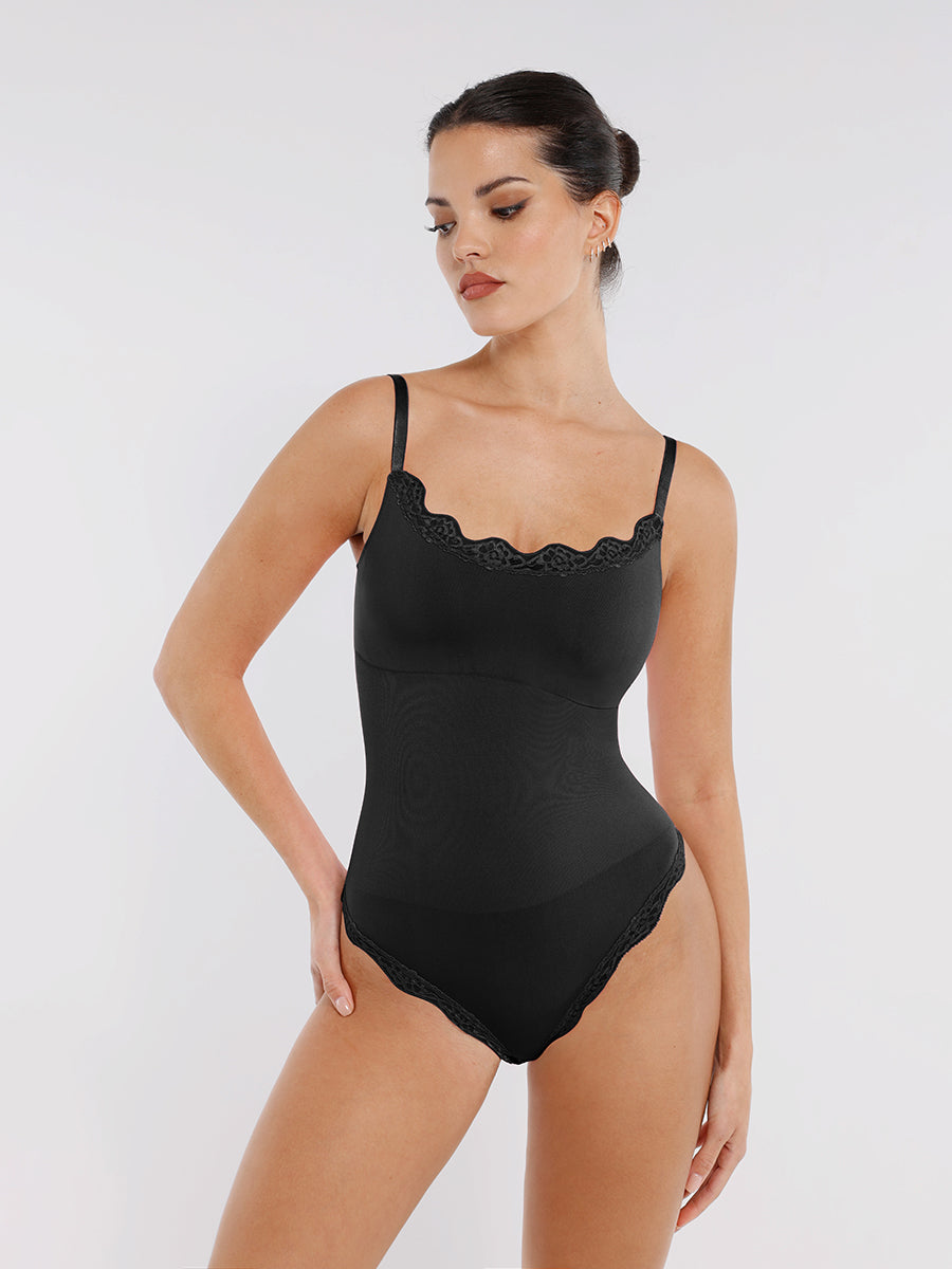 Model wearing a black bodysuit with lace details on a white background